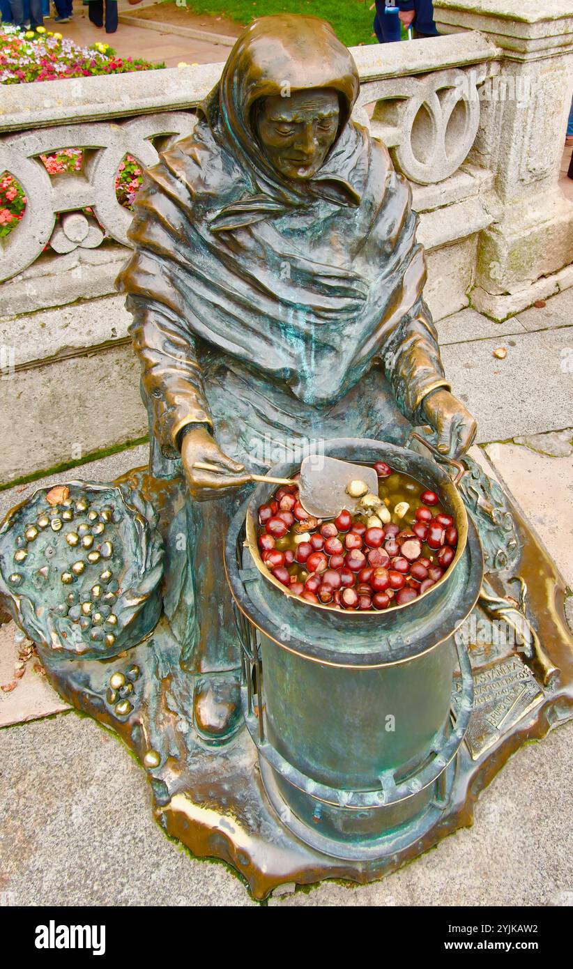 Statue de bronze de Bruno Cuevas assis vieille femme vendant des châtaignes rôties cuites sur tambour métallique près du pont Saint Mary Burgos Castille et Leon Espagne Banque D'Images