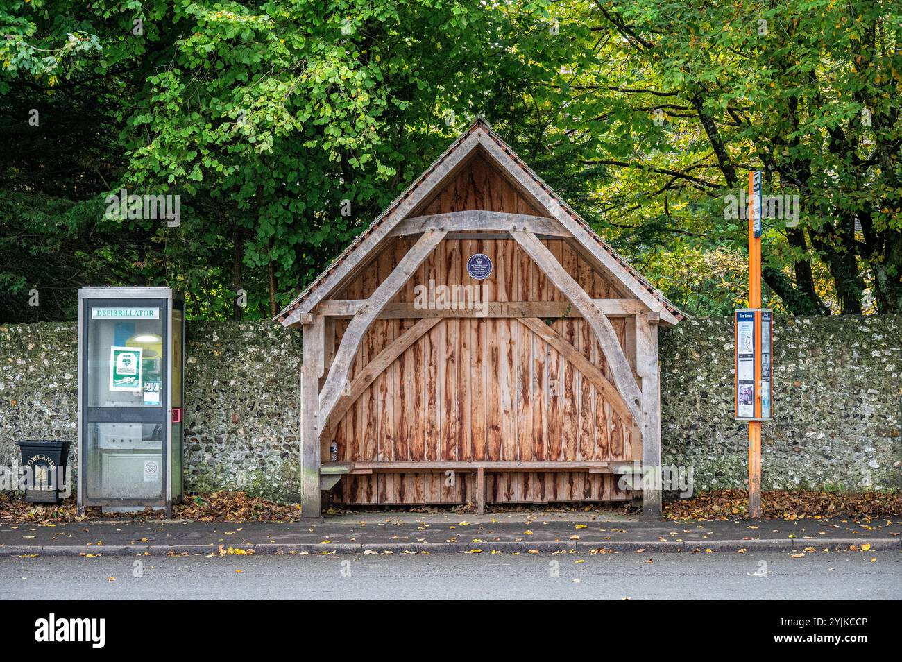Un abri de bus rural en bois et un défibrillateur à Rowlands Castle, Hampshire, Angleterre. Banque D'Images