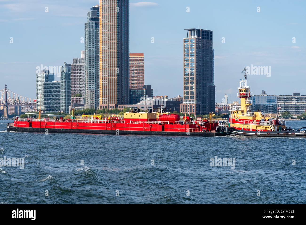 Un grand porte-conteneurs commercial rouge sur le fleuve Hudson avec des bâtiments en arrière-plan à New York, États-Unis. Banque D'Images