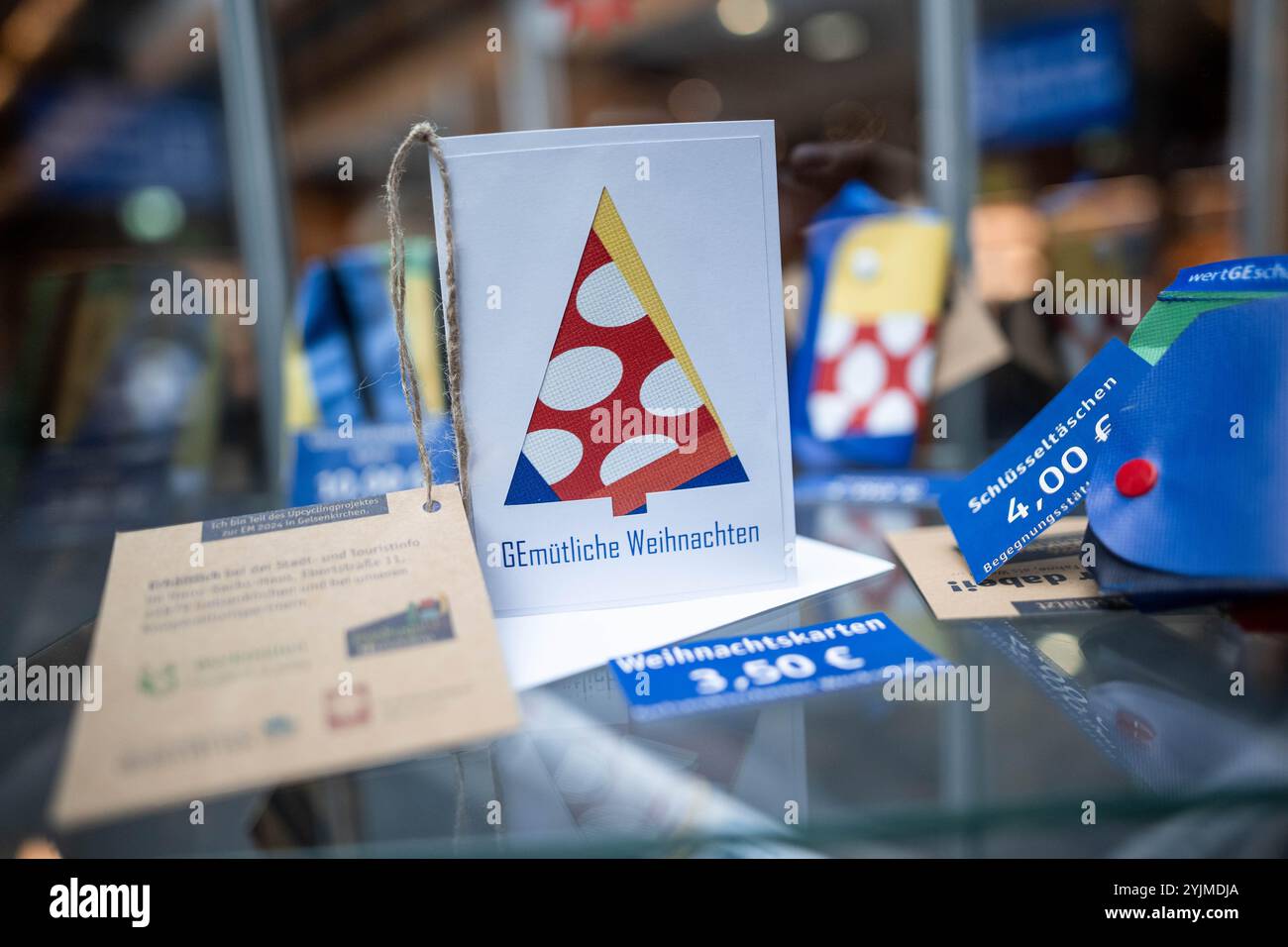 Gelsenkirchen, Allemagne. 15 novembre 2024. Une carte de Noël se tient dans une vitrine. Les produits fabriqués à partir de bannières, de bavoirs et de drapeaux du Championnat d'Europe sont maintenant vendus quatre mois après le Championnat d'Europe de football. Le projet est présenté par la ville et les partenaires de coopération. Les profits iront à une bonne cause. Crédit : Fabian Strauch/dpa/Alamy Live News Banque D'Images