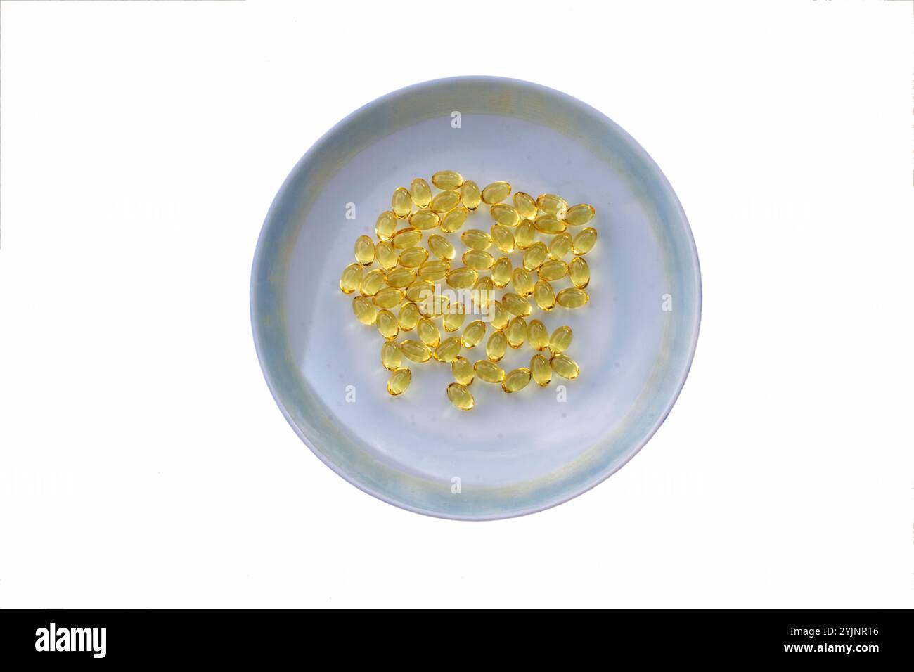 Capsules d'huile de foie de morue dans une plaque blanche Banque D'Images