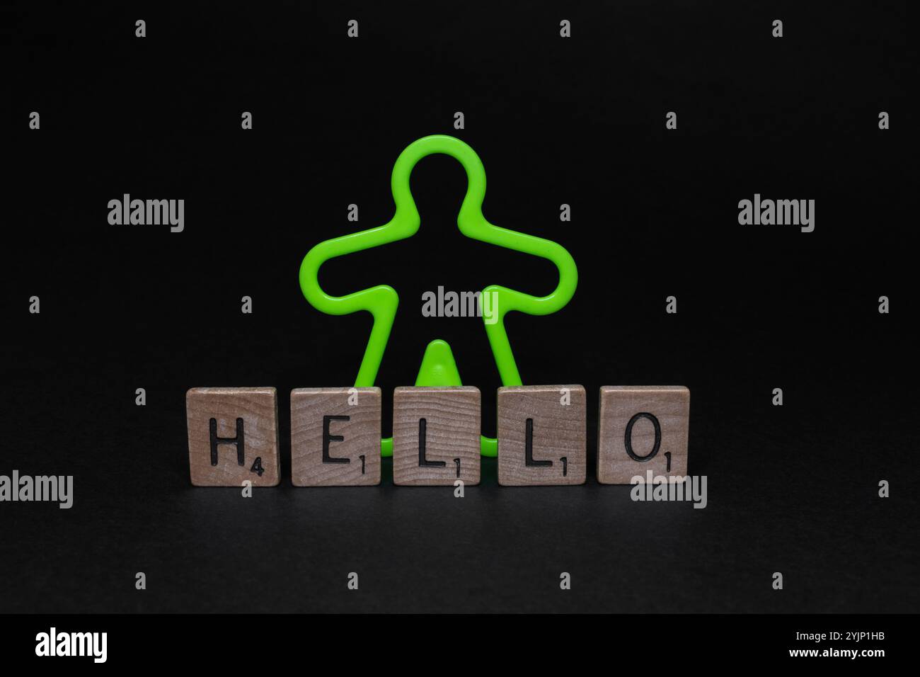 Gros plan de l'homme en plastique vert fluorescent avec des lettres "HELLO" sur la surface noire. Banque D'Images