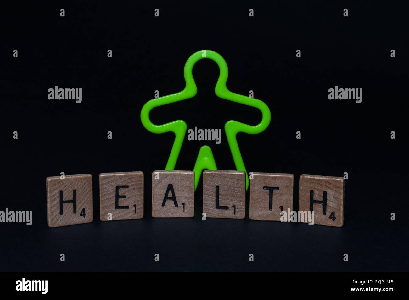Gros plan de l'homme en plastique vert fluorescent avec des lettres « SANTÉ » sur la surface noire Banque D'Images