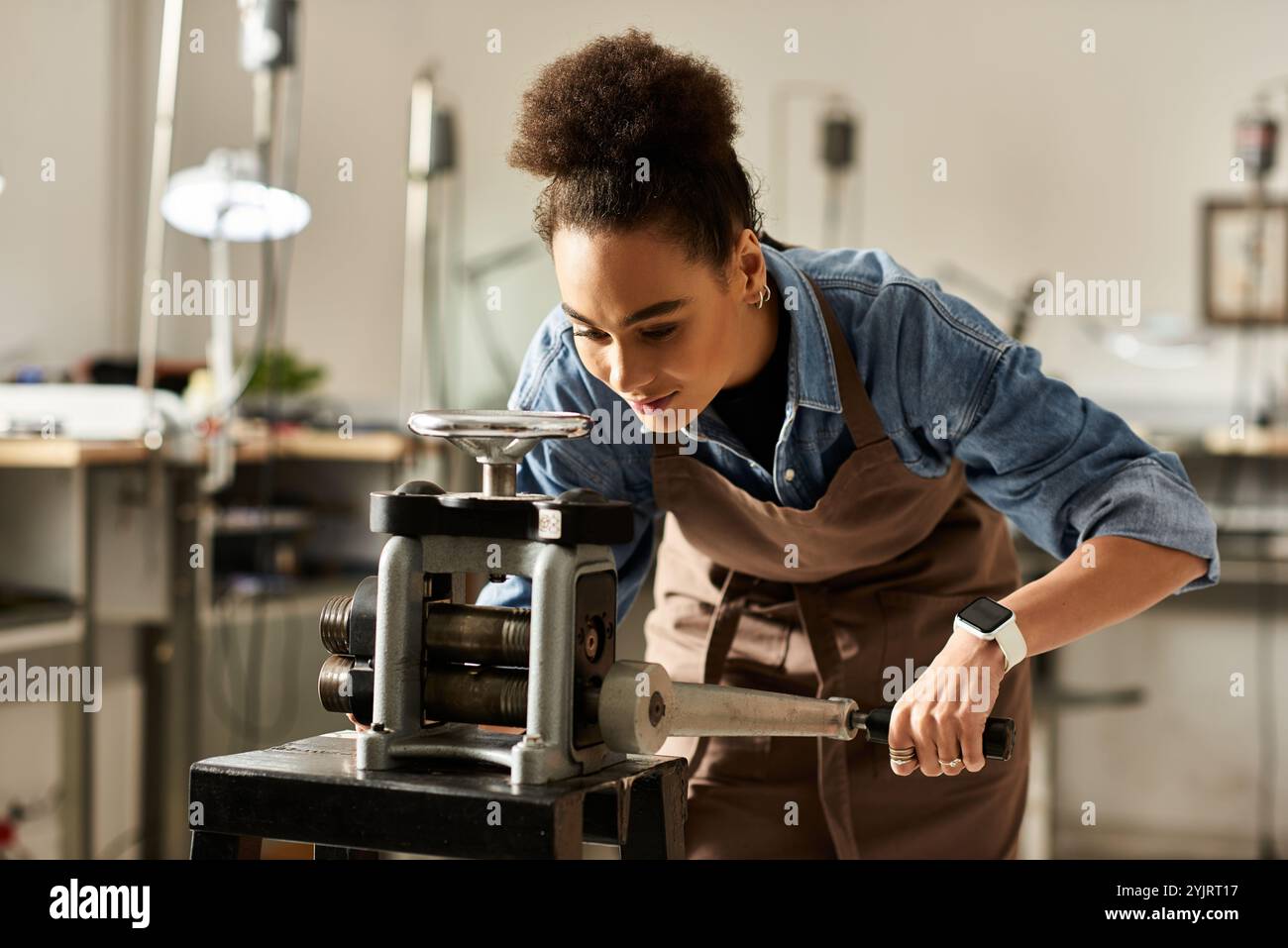 Une femme talentueuse travaille passionnément sur son processus de fabrication de bijoux dans un studio dynamique. Banque D'Images