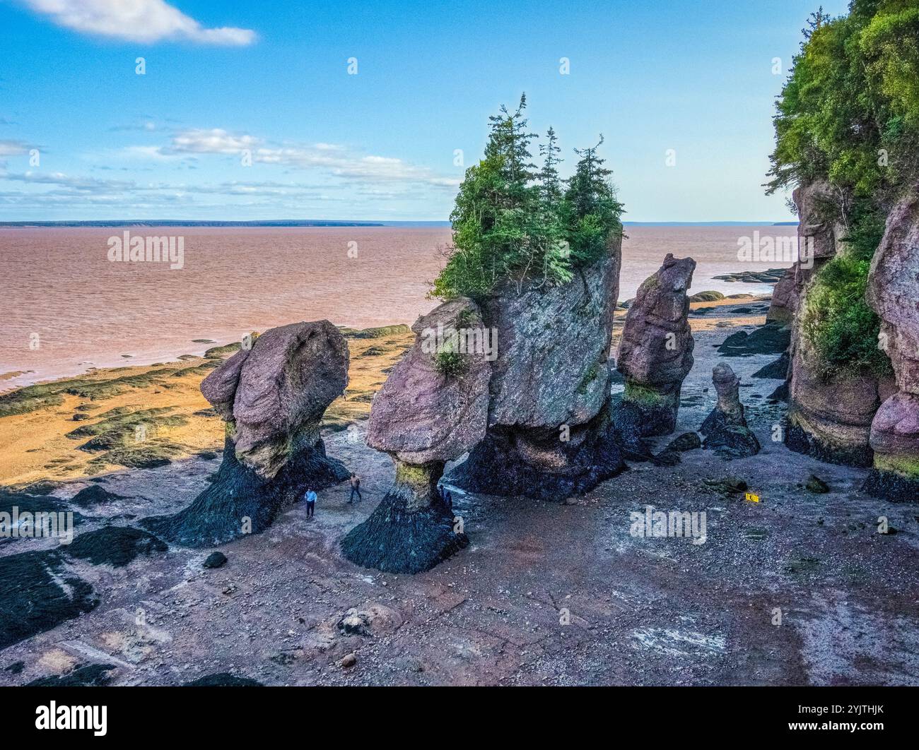 Peoplpe marchant dans Staircase Cove parmi les Sea Stacks sur le fond de l'océan à marée basse au parc provincial Hopewell Rocks au Nouveau-Brunswick Canada Banque D'Images