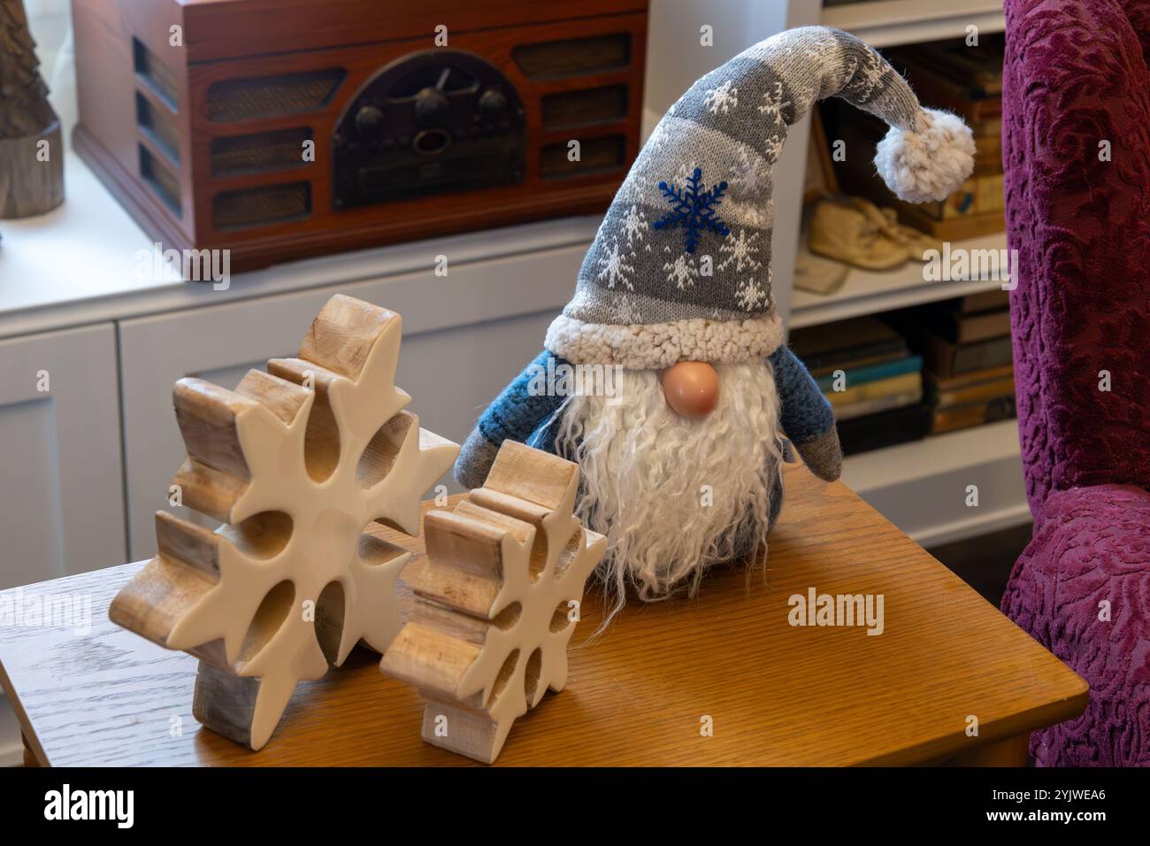 Cette image montre une petite table d'appoint décorée d'un gnome de Noël et de flocons de neige en bois Banque D'Images
