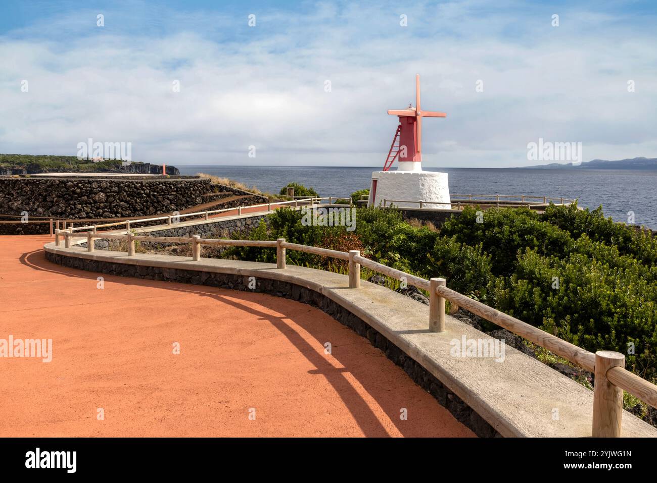 Le moulin à vent d'Urzelina, île de Sao Jorge, Açores, est situé à côté du petit port avec zone de baignade. Banque D'Images