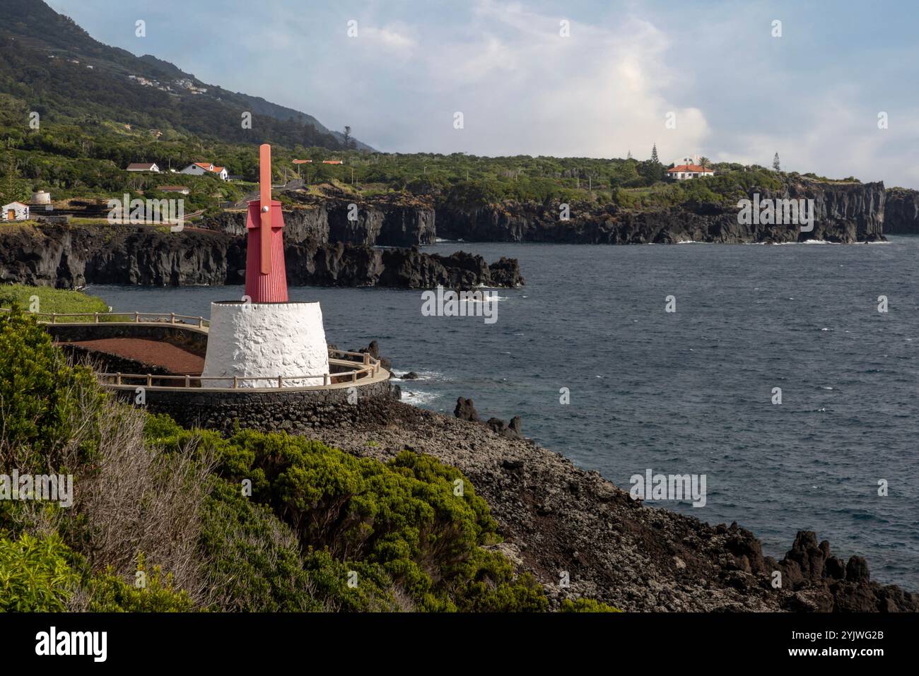 Le moulin à vent d'Urzelina, île de Sao Jorge, Açores, est situé à côté du petit port avec zone de baignade. Banque D'Images