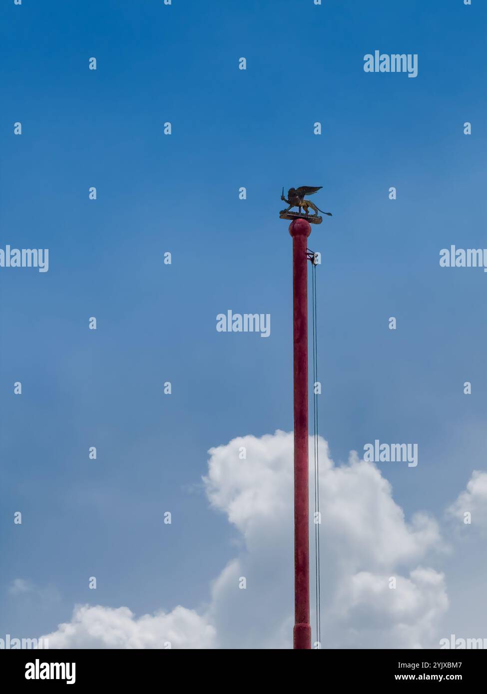 Portogruaor, Venise, Italie - 26 juin 2024 : mât de drapeau sur la Plazza della Republica devant le monument de guerre sous un nuage bleu, Lion ailé de Venise, Banque D'Images