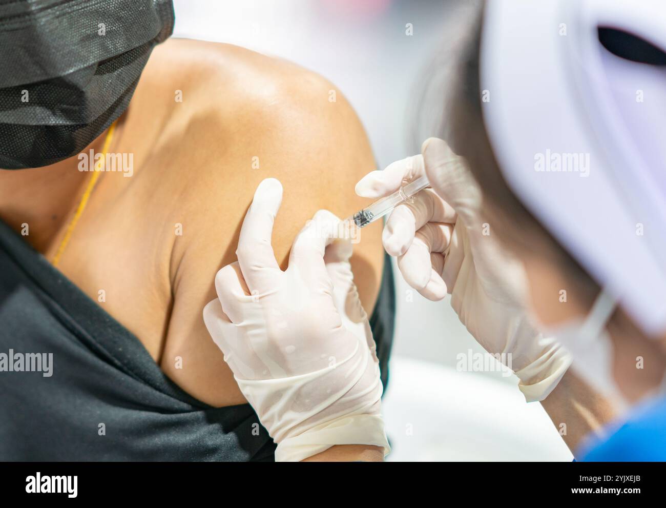 L'homme se faisant vacciner contre le coronavirus. L'infirmière injecte le vaccin à l'épaule à l'hôpital. Banque D'Images