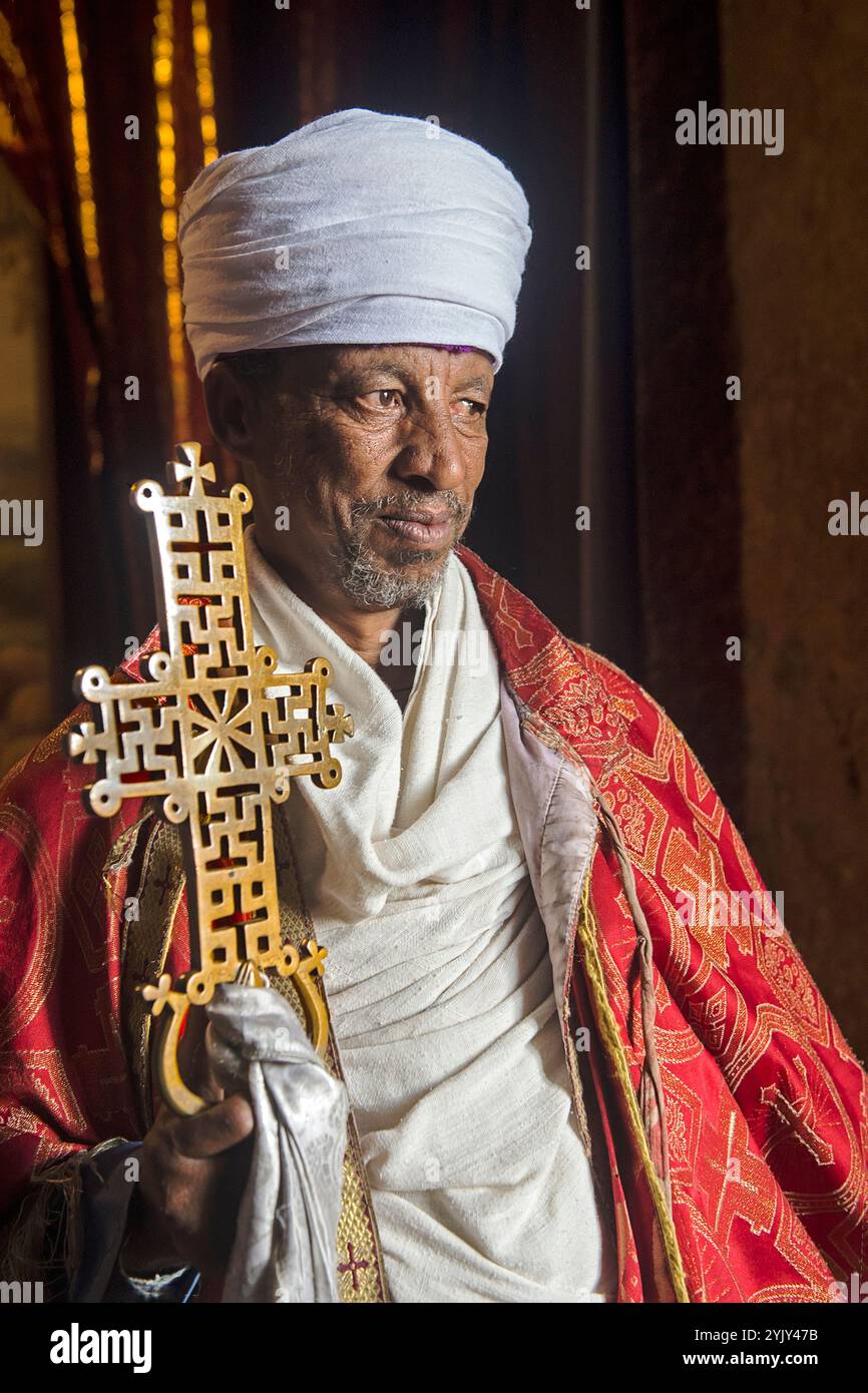 Prêtre tenant une croix processionnelle en laiton composée de croix de plaine et de croix de Tau, Lalibela, Ethiopie Banque D'Images