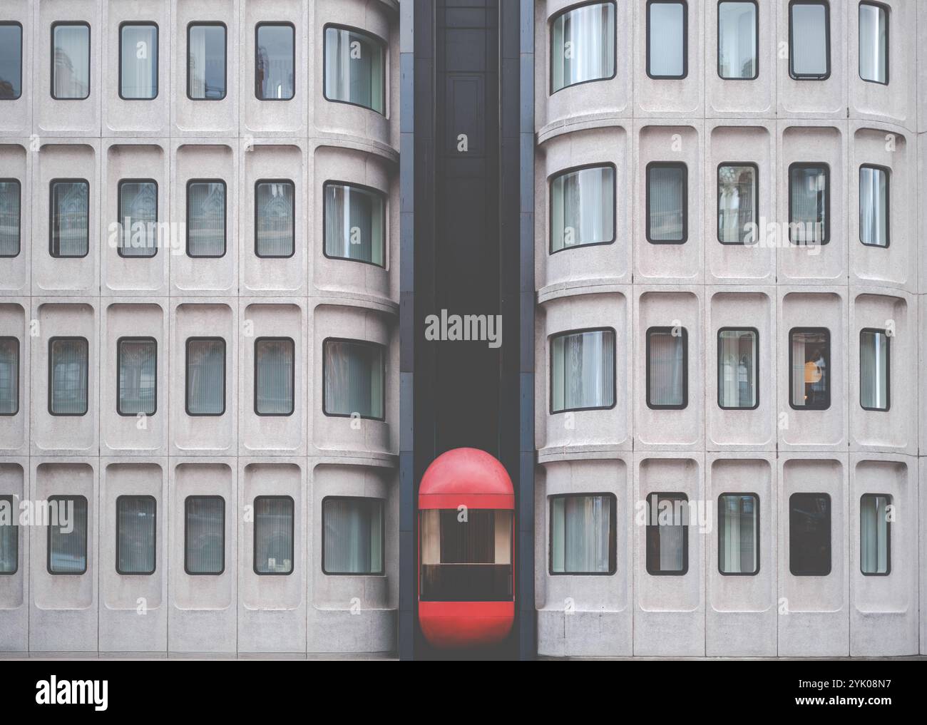 Un ascenseur extérieur rouge frappant (ascenseur) sur Un bâtiment dans le style brutaliste Arhitecture Banque D'Images