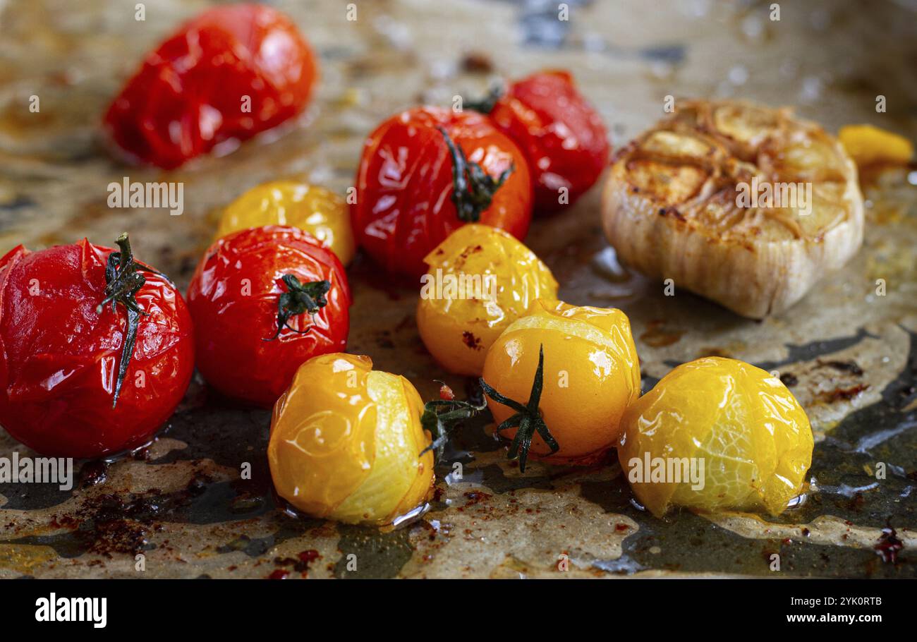 Tomates cerises cuites au four, sur une plaque de cuisson, avec de l'huile d'olive et des épices, gros plan, mise au point sélective, fait maison, pas de gens Banque D'Images