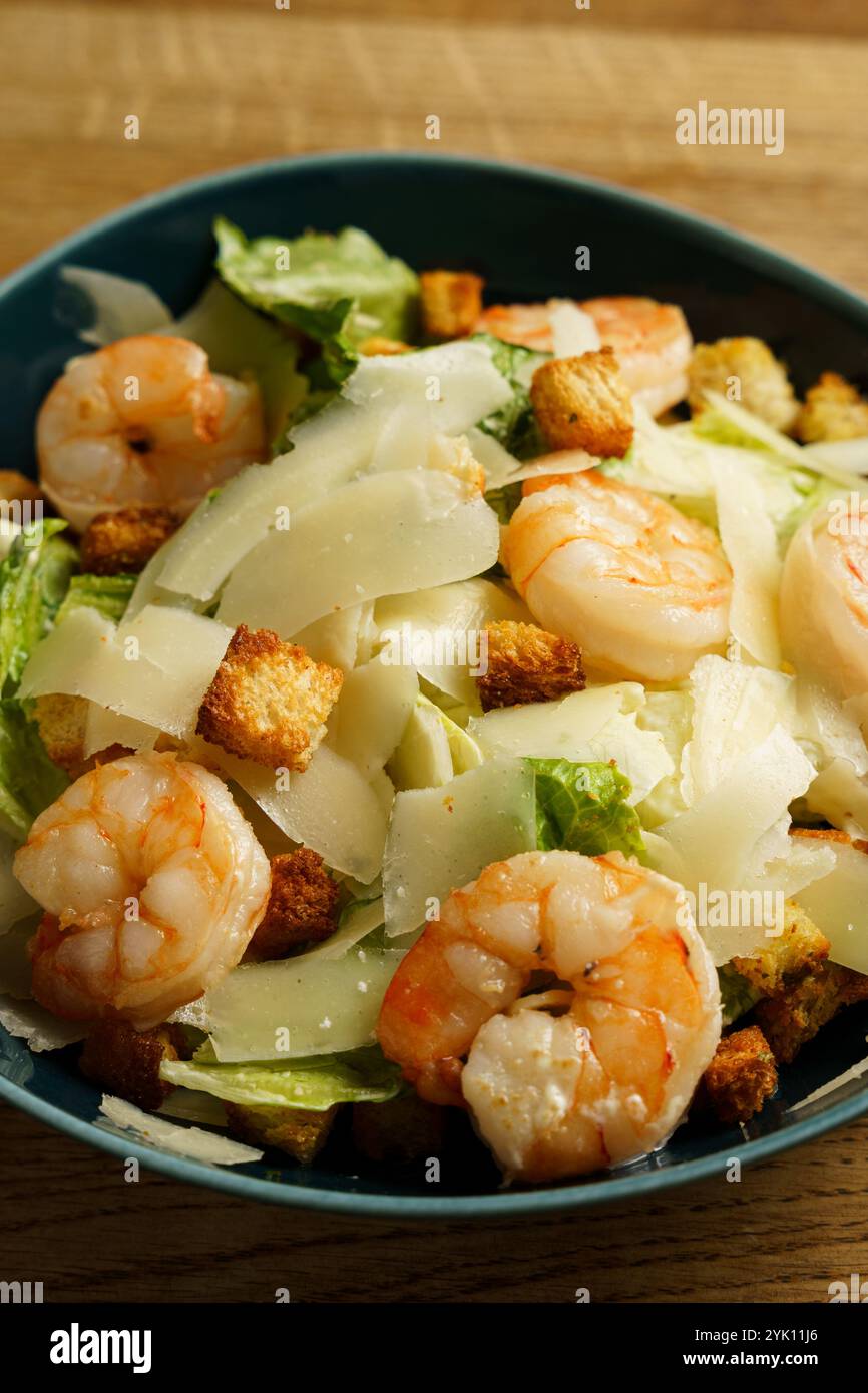 Un bol copieux de salade César de crevettes composé de crevettes, de laitue romaine croustillante, de croûtons croquants et de parmesan finement rasé. Le plat est servi Banque D'Images