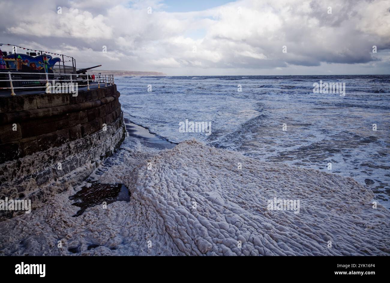 La mer agitée engloutit l'écume marine à Whitby Beach, North Yorkshire, Angleterre. Banque D'Images
