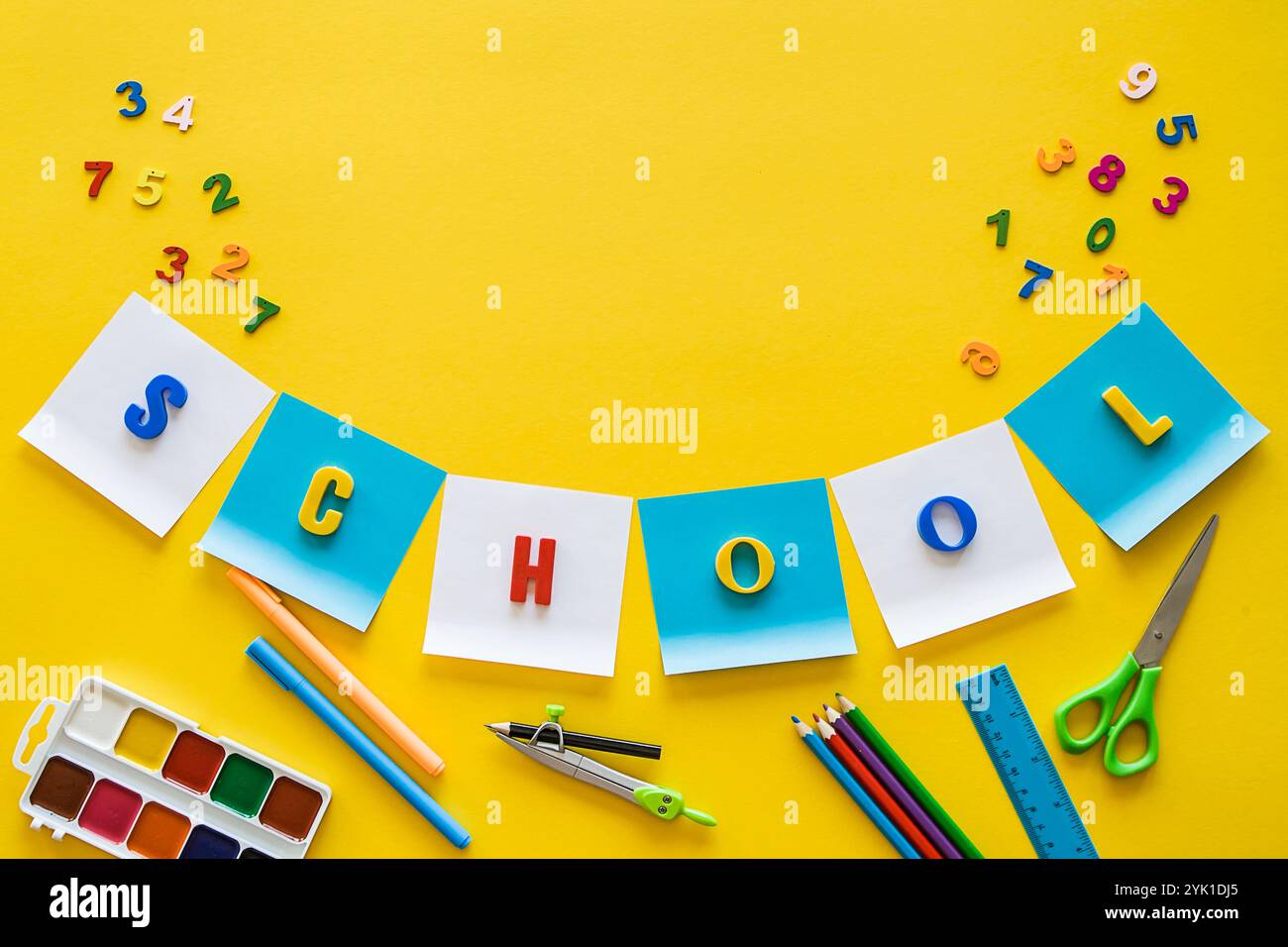 Concept de retour à l'école. École de lettres colorées. fournitures scolaires sur fond jaune, espace de copie. Pose à plat de fournitures scolaires ou maternelles. Banque D'Images