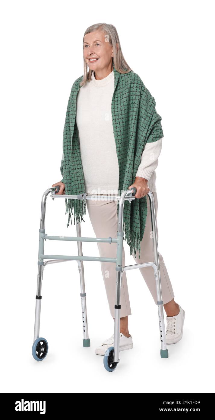 Femme senior utilisant le cadre de marche sur fond blanc Banque D'Images