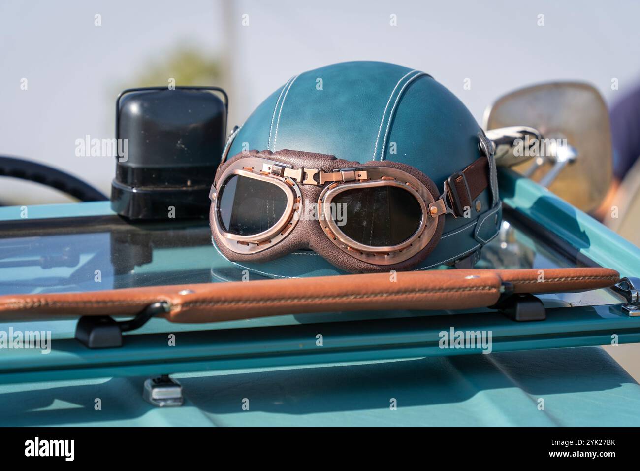 Casque de voiture vintage bleu-vert et lunettes sur une vieille voiture Banque D'Images