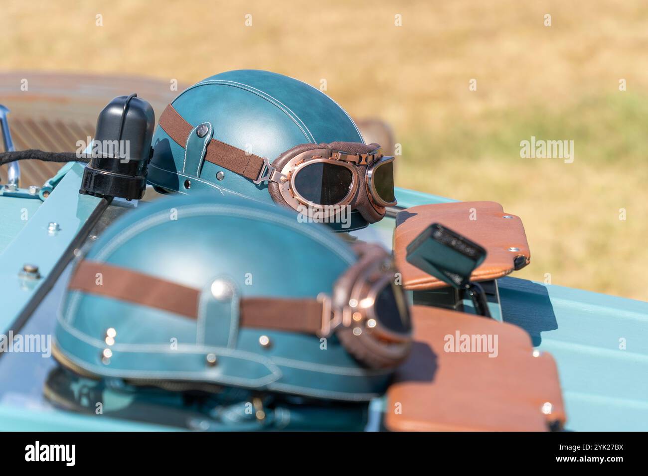 Casque de voiture vintage bleu-vert et lunettes sur une vieille voiture Banque D'Images