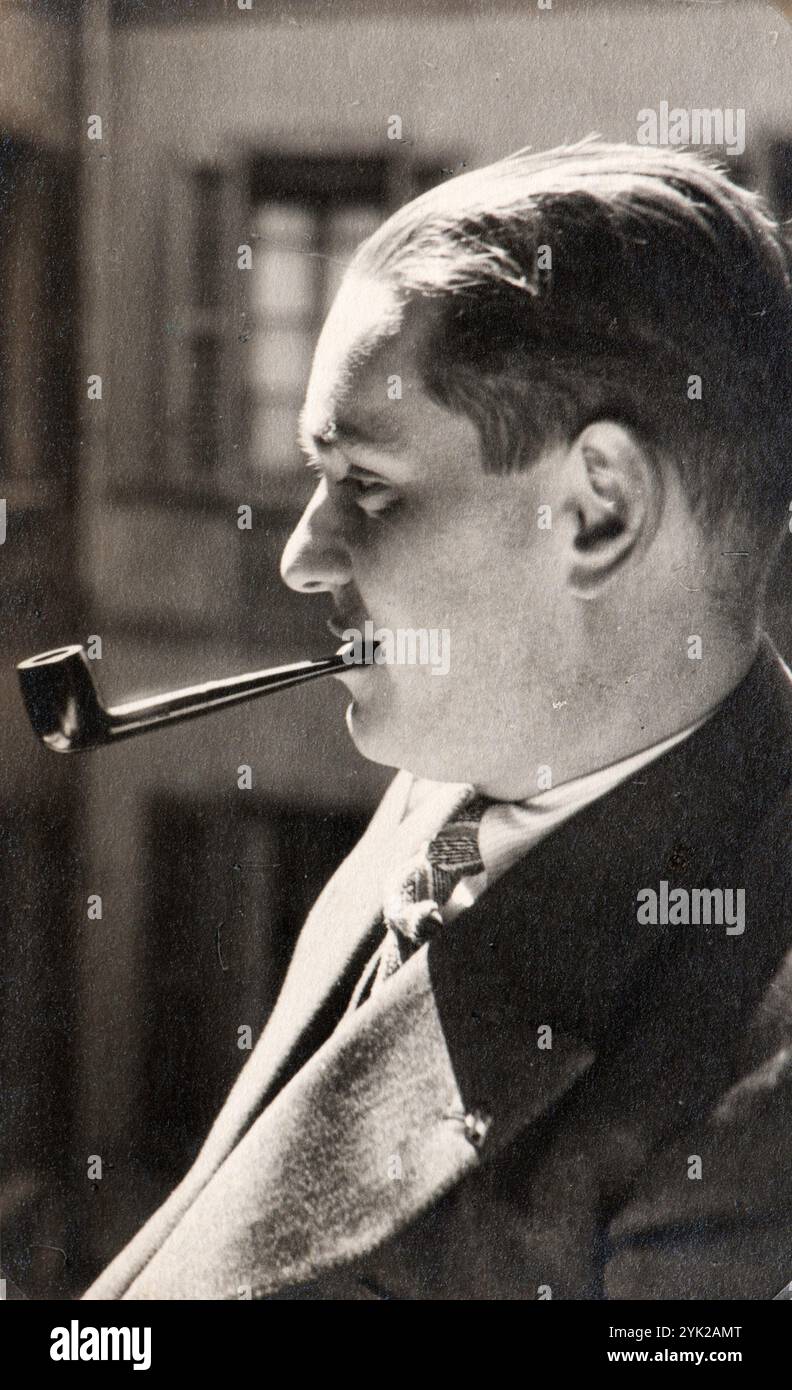 Homme italien posant pour un portrait tout en fumant une pipe dans un moment de détente. La photo a été prise au milieu des années trente à Milan Banque D'Images