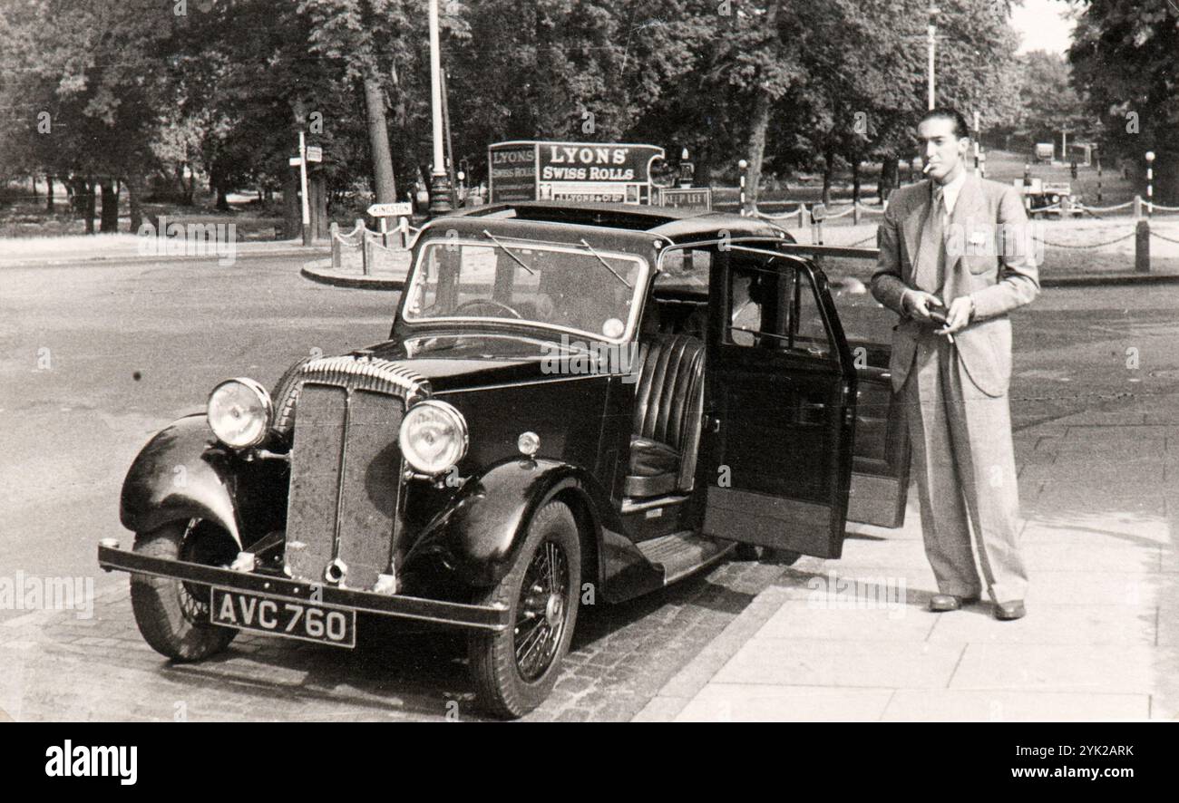 Un italien pose pour une photo près de la voiture qu'il a louée afin de se rendre en Angleterre. La photo a été prise au milieu des années trente Banque D'Images