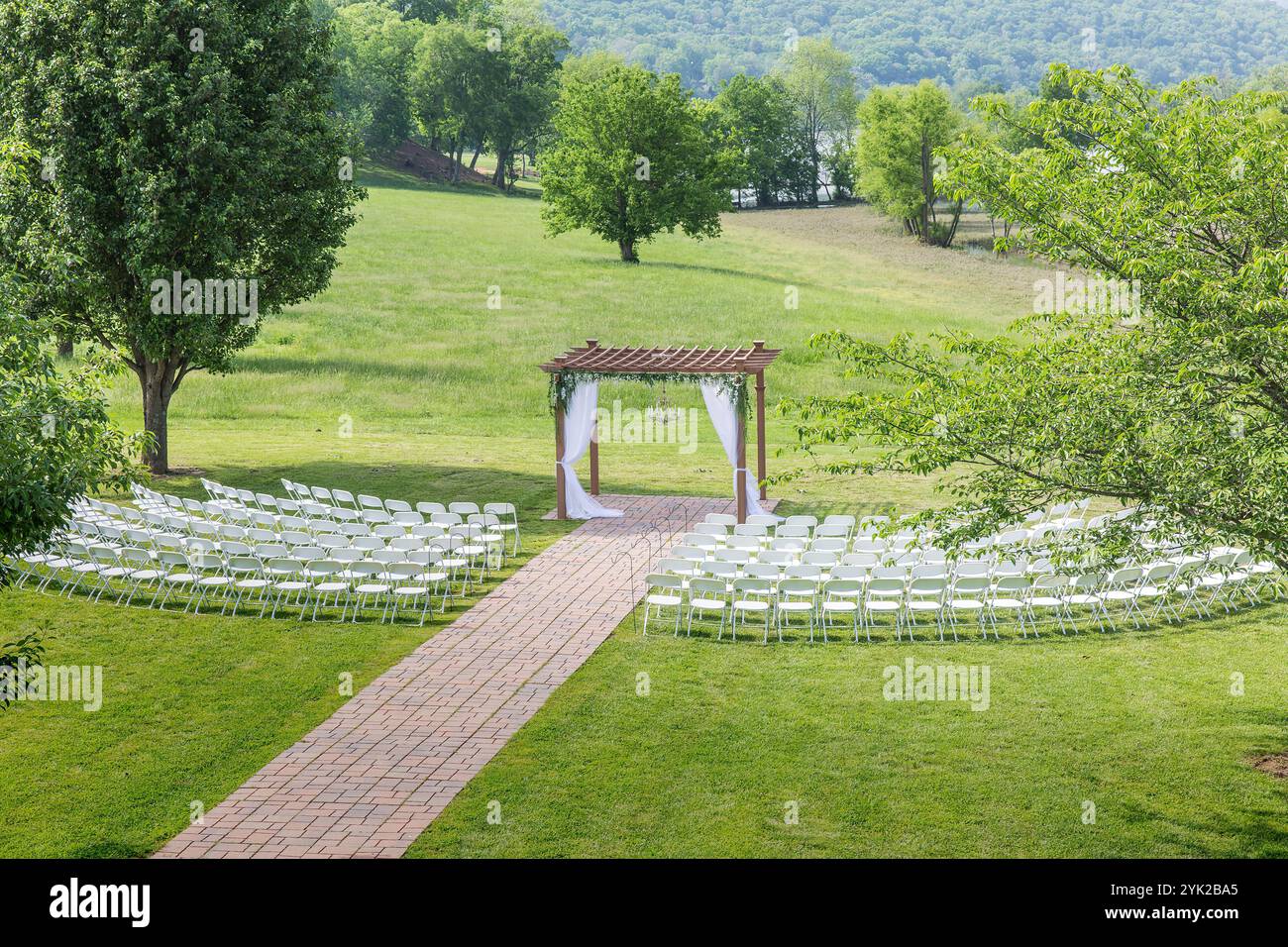Élégante configuration de mariage en plein air avec décorations florales et toile de fond panoramique Banque D'Images Élégante configuration de mariage en plein air avec décorations florales et toile de fond panoramique Banque D'Images