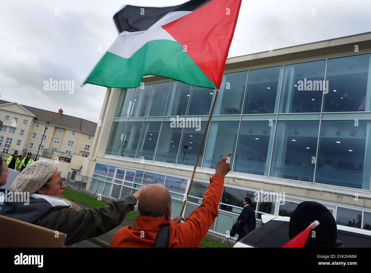 Conwy, Royaume-Uni. 16 novembre 2024. Un partisan pro-palestinien tient un drapeau pendant la manifestation. Les partisans pro-palestiniens du nord du pays de Galles sont descendus dans la rue à nouveau lors de la conférence du Parti travailliste gallois à Llandudno. Les manifestants portaient une réplique de "bébés morts" enveloppés dans des enveloppes et criaient "HONTE À VOUS" et "PALESTINE LIBRE" devant le lieu de la conférence, en colère contre la position du premier ministre britannique, Sir Keir Starmer sur la guerre à Gaza et au Liban et le silence de son parti sur les morts et les souffrances d'hommes, de femmes et d'enfants innocents dans le conflit. Crédit : SOPA images Limited/Alamy Live News Banque D'Images