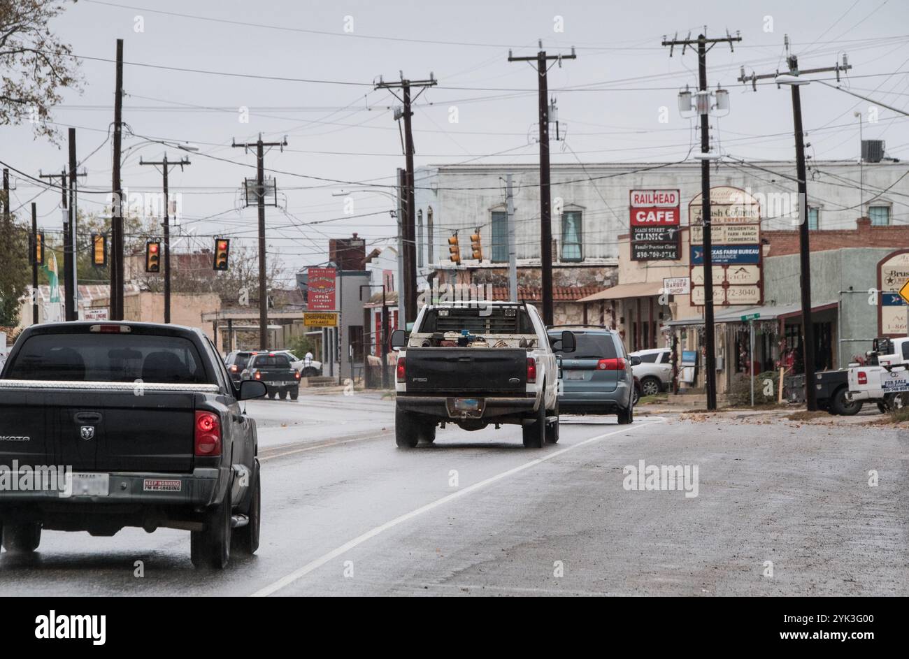 Le trafic du matin près de l'ancien emplacement de la Lytle Community Health Centre, le bâtiment sur la droite avec parement en acier ondulé, sur la rue Main, à Lytle, Texas, le 5 décembre 2017. Le nom est encore visible sur le rectangle avec les autres commerces dans l'immeuble. Ce centre de santé (SC) est une clinique satellite d'Atascosa Health Center, Inc., qui s'est qualifié et a été approuvé par le ministère de l'Agriculture des États-Unis (USDA) Développement Rural (RD) établissement communautaire Programme de prêts directs pour un prêt direct de 1 450 000 $. Les fonds ont permis l'achat d'un immeuble de bureaux médicaux existants que j Banque D'Images