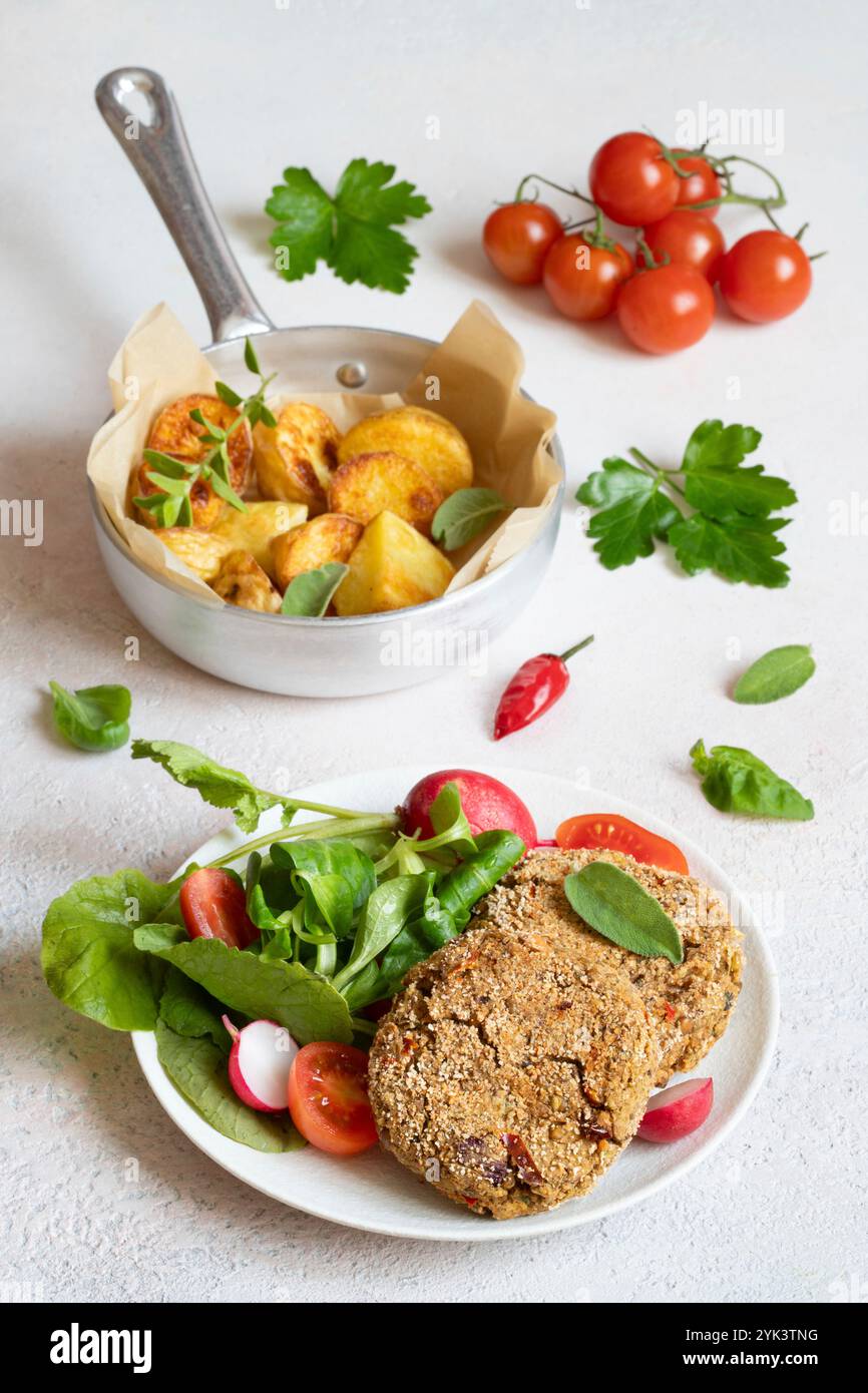 Galettes de lentilles avec pommes de terre rôties et salade Banque D'Images