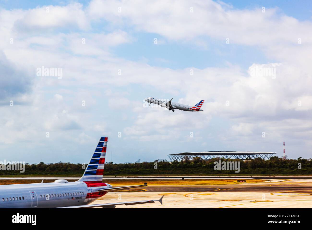 Avion d'American Airlines décollant de l'aéroport de Cancun, Mexique, sous un ciel partiellement nuageux. Cancun. Mexique. Banque D'Images