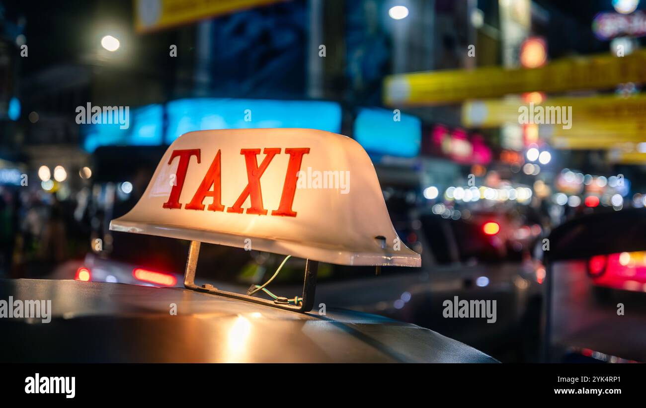 Panneau lumineux de taxi sur le toit tuk tuk la nuit. Rue animée de Bangkok, Thaïlande Banque D'Images