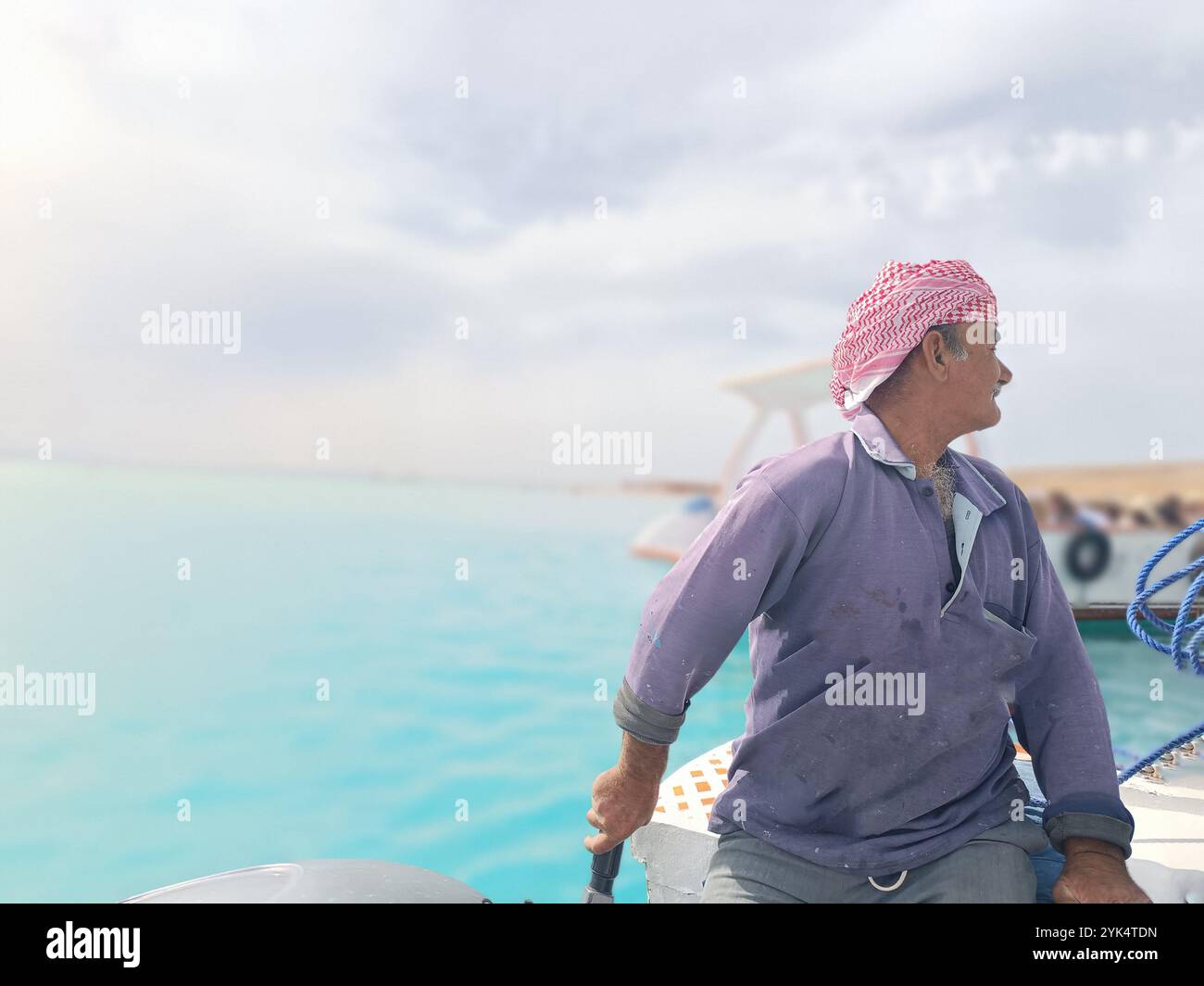 Vieux marin dans la mer équitation et voile avec son bateau un vieux marin avec un blanc avec une moustache blanche qui porte une écharpe bédouine sur sa tête Banque D'Images