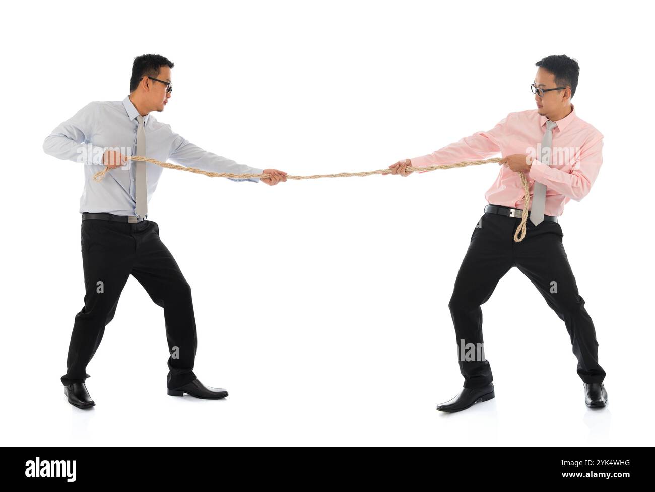 Deux hommes d'affaires asiatiques tirant une corde corps plein deux hommes d'affaires asiatiques tirant une corde, isolés sur fond blanc. Modèle masculin asiatique. Droit d'auteur : xZoona Banque D'Images