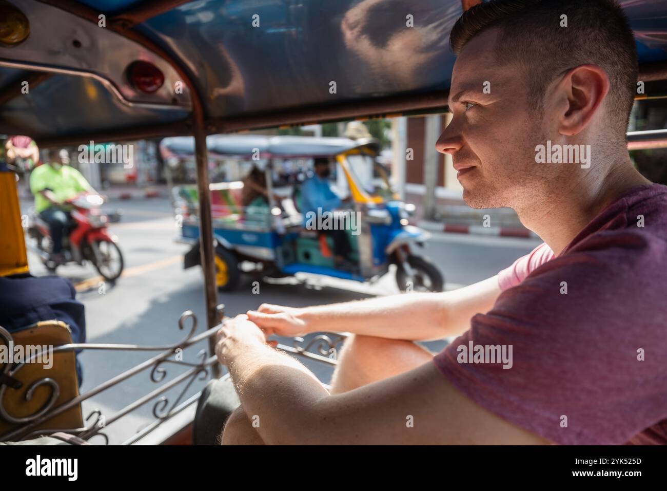 Homme appréciant tuk tuk ride pendant la journée ensoleillée. Portrait de touriste en taxi à Bagkok, Thaïlande. Banque D'Images
