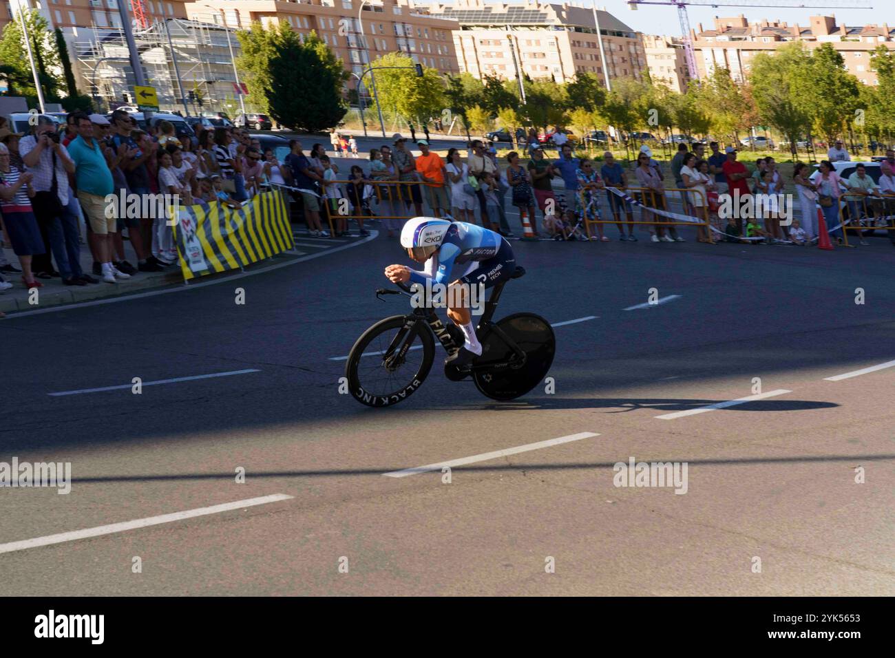 Madrid, Espagne, 09/2024 : contre-la-montre à Madrid via Sanchinarro. Cycliste dans une course arrondissant un coin sur une rue de la ville, avec des spectateurs et des officiels wa Banque D'Images