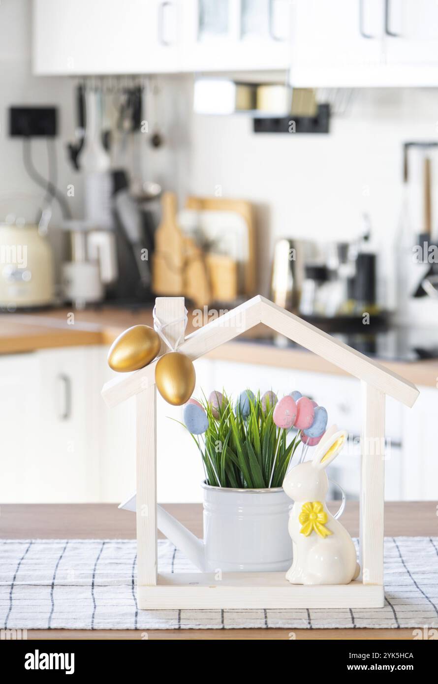Petite maison de maison confortable avec décor de Pâques avec lapin et oeufs sur la table de la cuisine. Bâtiment, conception, projet, déménagement à la nouvelle maison, hypothèque, insuranc Banque D'Images