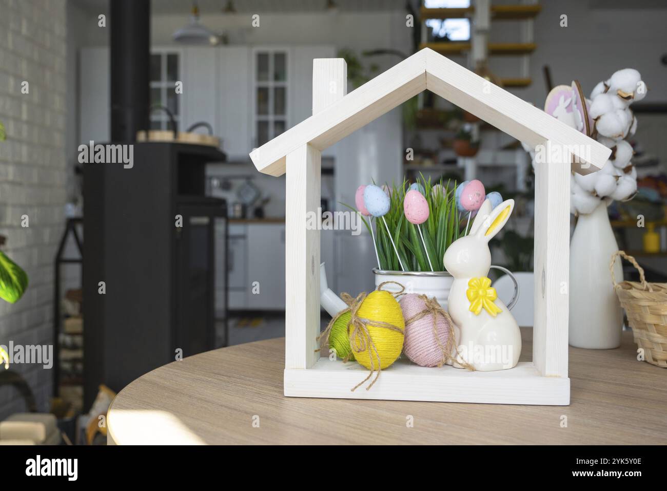 Petite maison de maison confortable avec décor de Pâques avec lapin et oeufs sur la table de la cuisine. Bâtiment, conception, projet, déménagement à la nouvelle maison, hypothèque, insuranc Banque D'Images