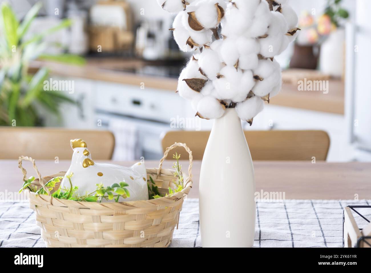 Décoration de Pâques avec œufs colorés dans un panier et poulet sur la table de cuisine dans un style rustique. Intérieur festif d'une maison de campagne Banque D'Images
