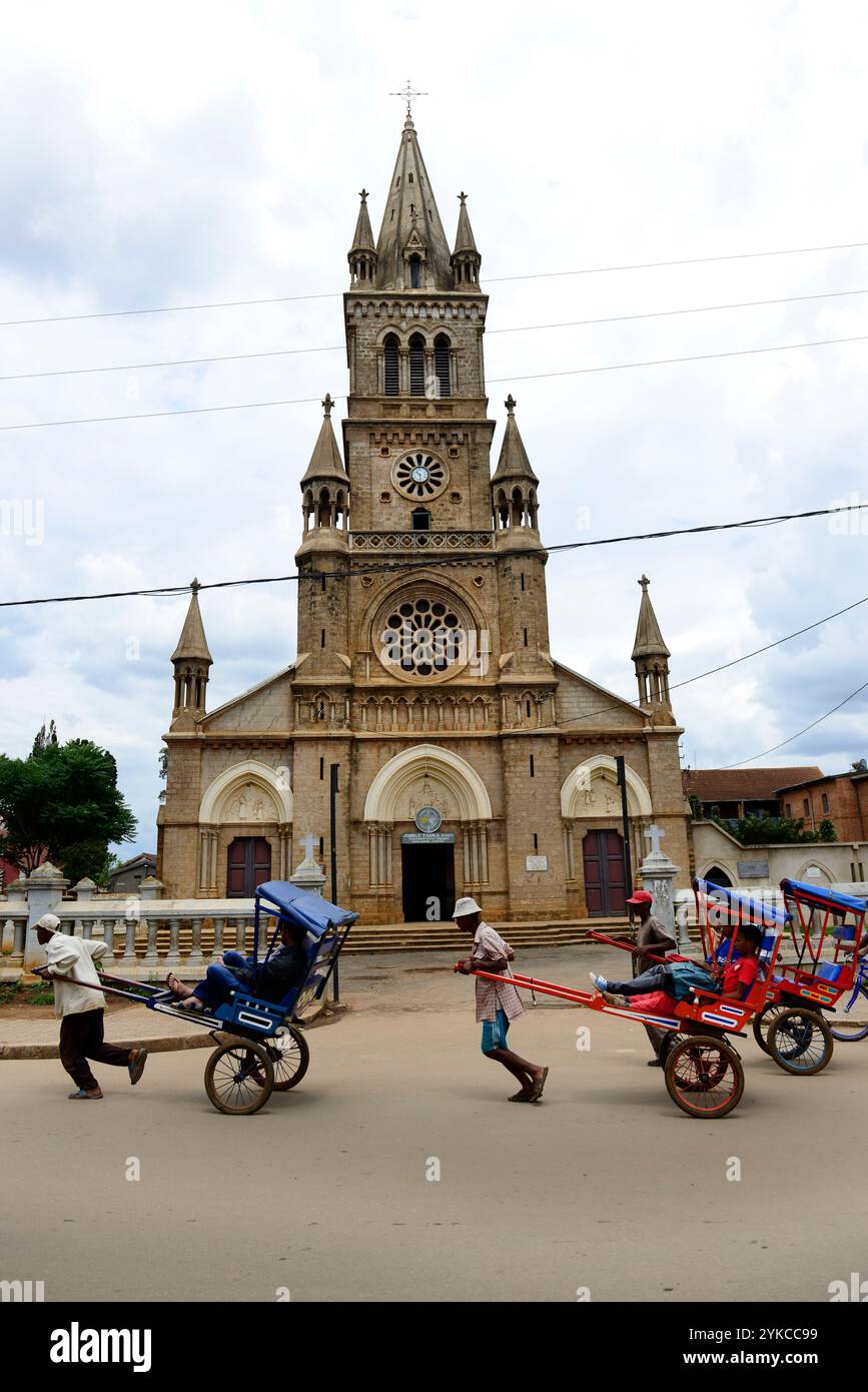 Un Pous Pous conducteur par la cathédrale dans le centre d'Antsirabe à Madagascar. Banque D'Images