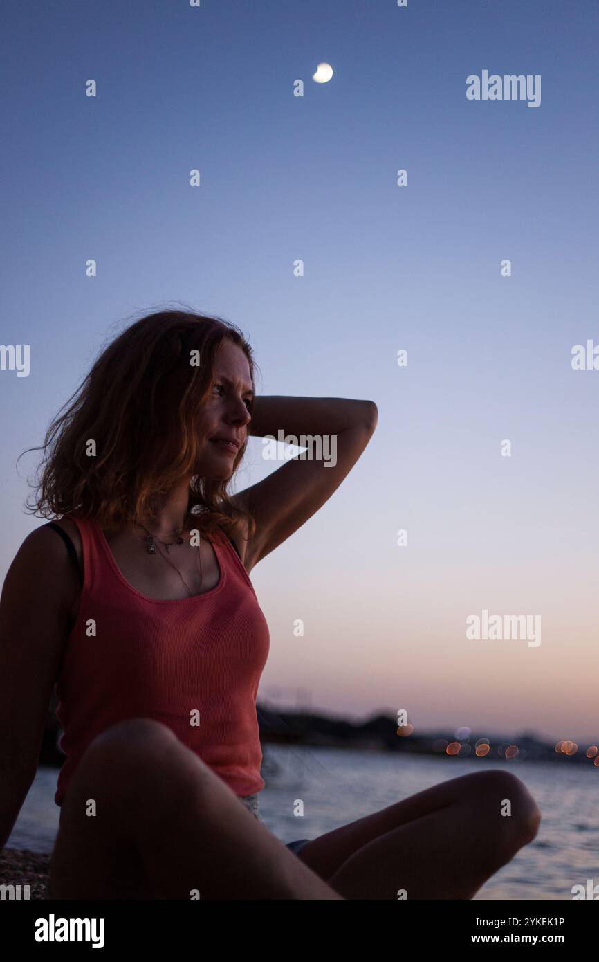 Femme en silhouette sous la lune du soir Banque D'Images