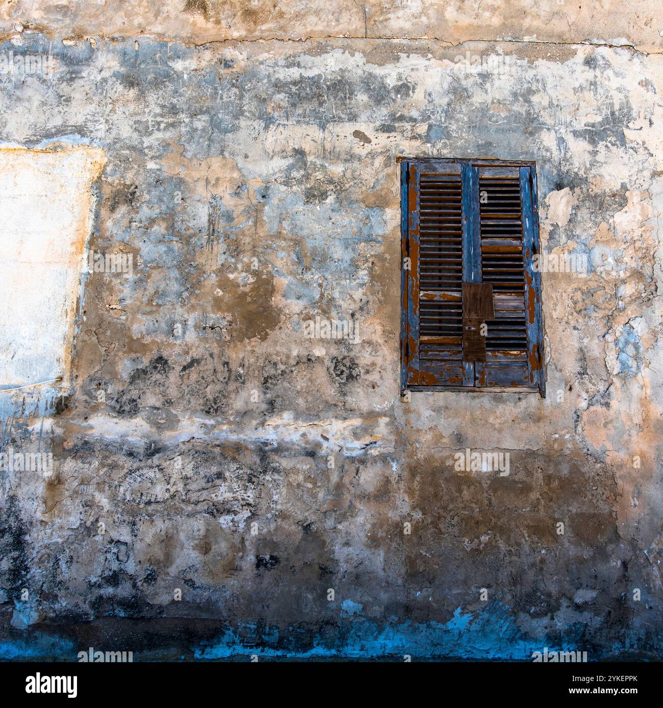 Vieille fenêtre en bois vert avec rideaux bleus et blancs dans l'île de Favignana à Trapani Sicile Italie Banque D'Images
