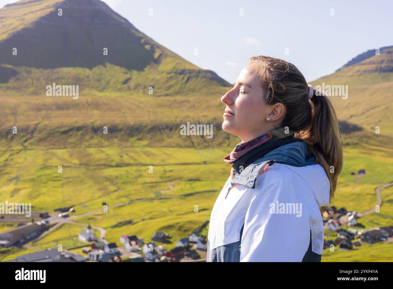 Paisible jeune femme prenant une profonde respiration à Gjogv dans les îles Féroé contemplation, pleine conscience, tranquillité et détente dans la montagne Banque D'Images
