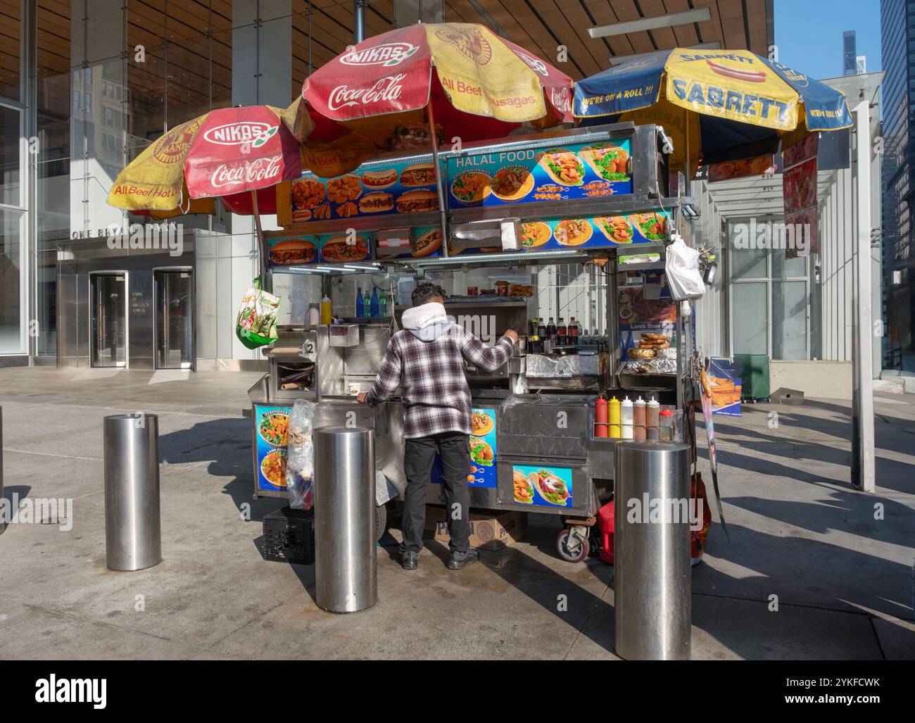 Un vendeur probablement un immigrant, exploitant un stand de hot-dog fast food sur la 42e rue à Midtown Manhattan. Banque D'Images