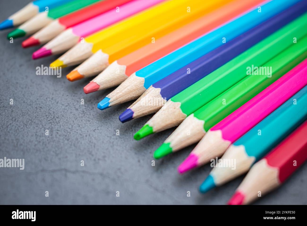 Ensemble de crayons de couleur alignés sur un fond gris Banque D'Images