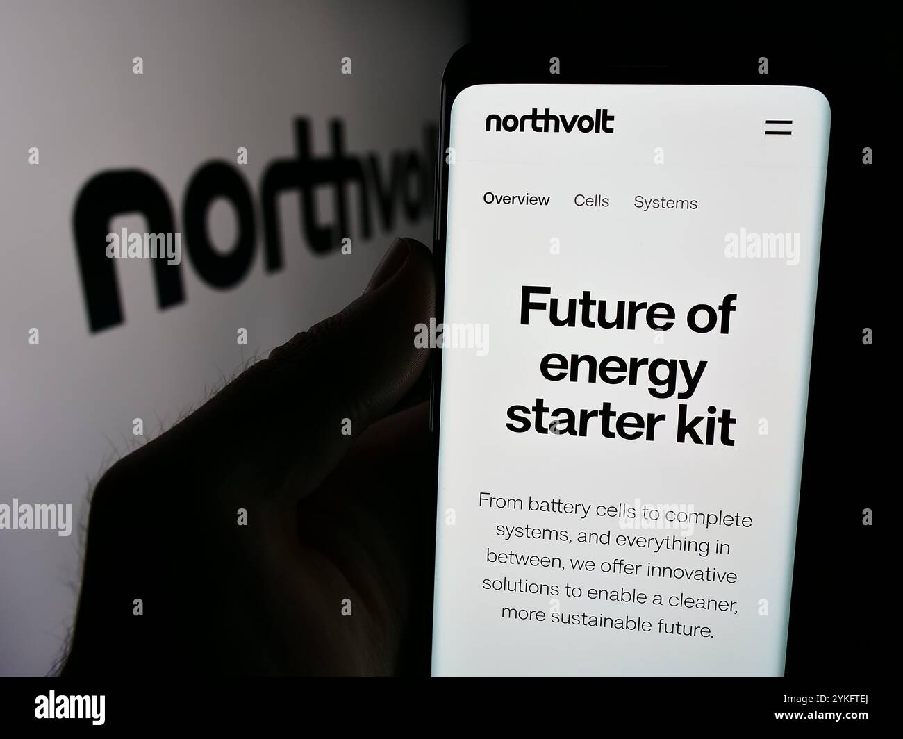 13 août 2024, Allemagne : dans cette illustration photo, un homme tient un smartphone avec le site de la société suédoise de batteries Northvolt AB devant le logo de l'entreprise. (Crédit image : © timon Schneider/SOPA images via ZUMA Press Wire) USAGE ÉDITORIAL SEULEMENT ! Non destiné à UN USAGE commercial ! Banque D'Images