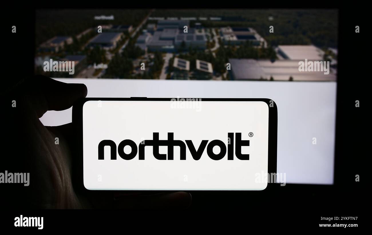 13 août 2024, Allemagne : dans cette illustration photo, un homme tient un téléphone portable avec le logo de la compagnie suédoise de batteries Northvolt AB devant la page Web de l'entreprise. (Crédit image : © timon Schneider/SOPA images via ZUMA Press Wire) USAGE ÉDITORIAL SEULEMENT ! Non destiné à UN USAGE commercial ! Banque D'Images
