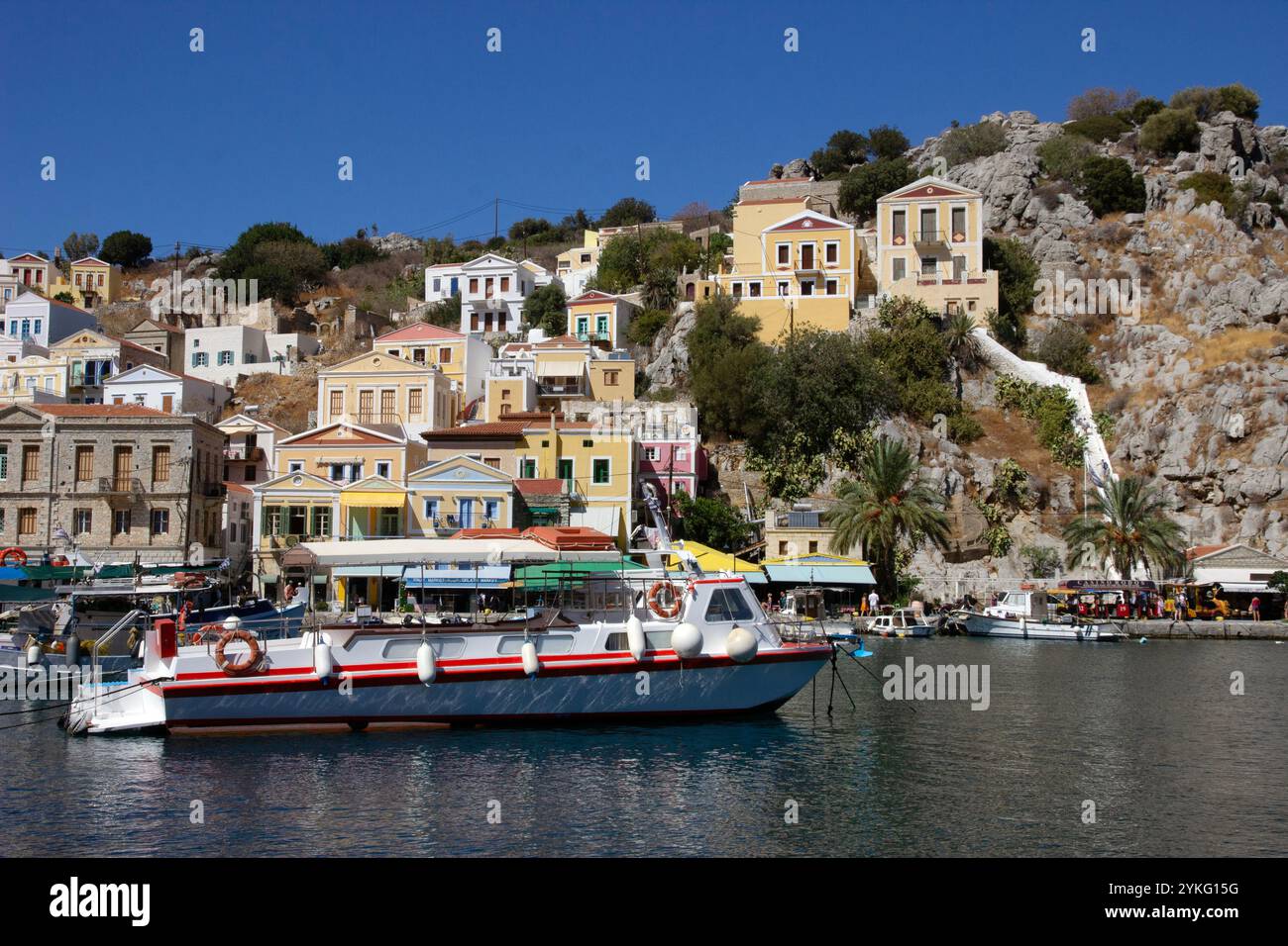 Le port de la ville de Symi sur l'île grecque de Symi dans la chaîne d'îles du Dodécanèse, avec ses maisons colorées dans des styles néo-classiques. Banque D'Images