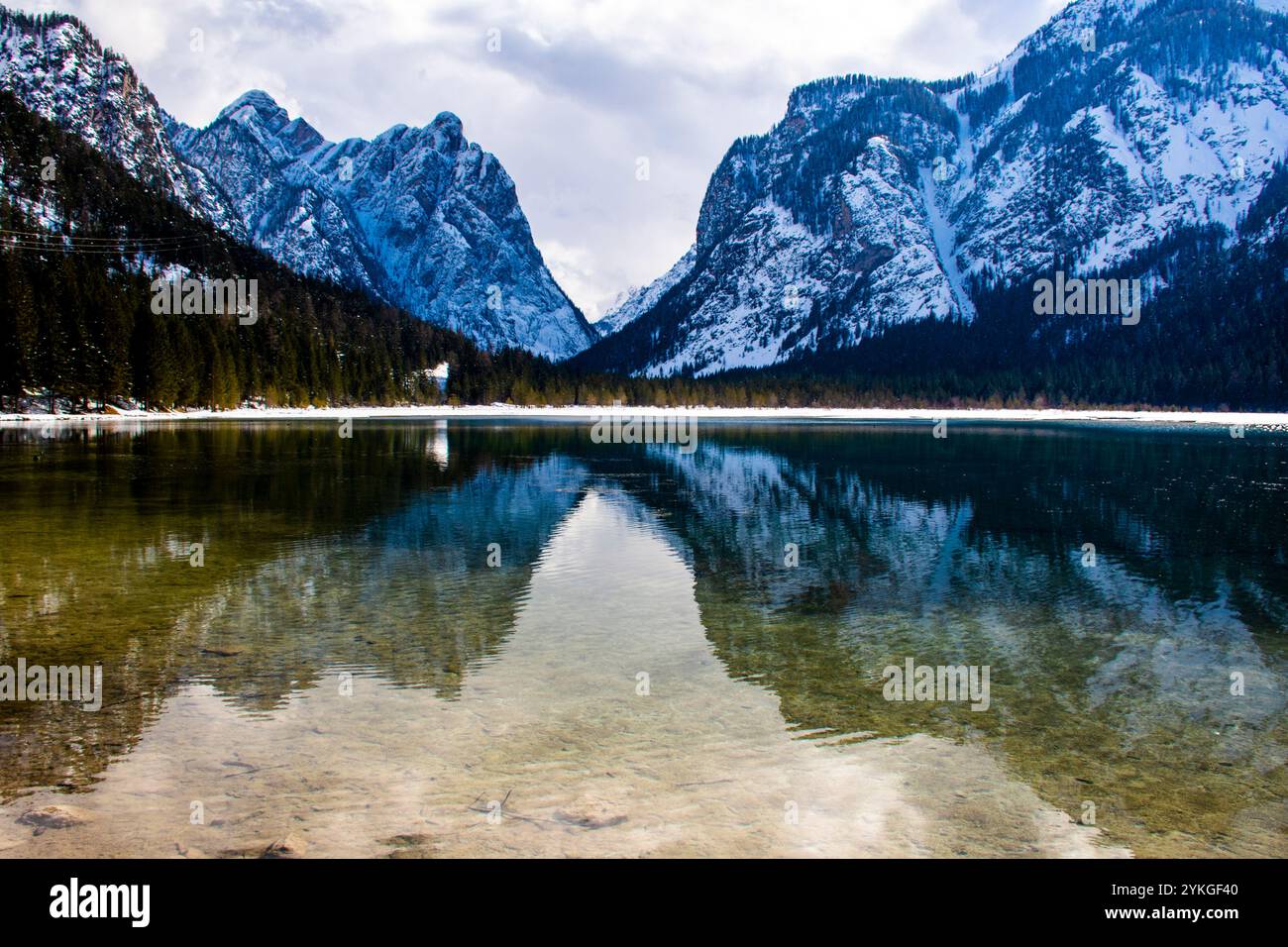 Les montagnes enneigées se reflètent sur le lac Dobbiaco au milieu des dolomites Banque D'Images
