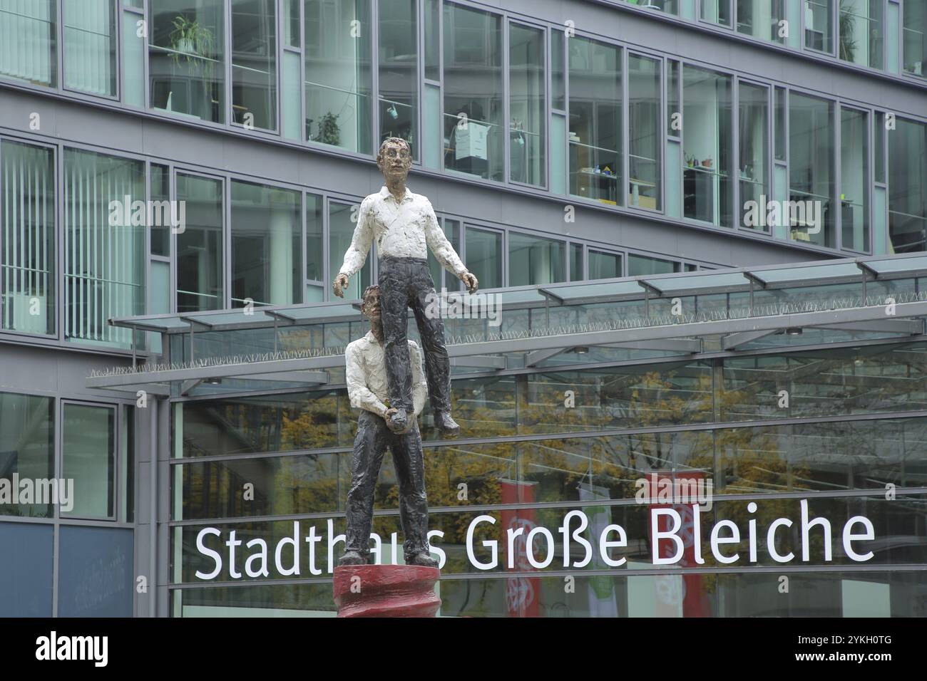 Maison de ville avec sculpture deux hommes par Stephan Balkenhol 2001, figure masculine, debout sur une jambe, porter, soulever, soulever, haut, au-dessus, force, acrob Banque D'Images