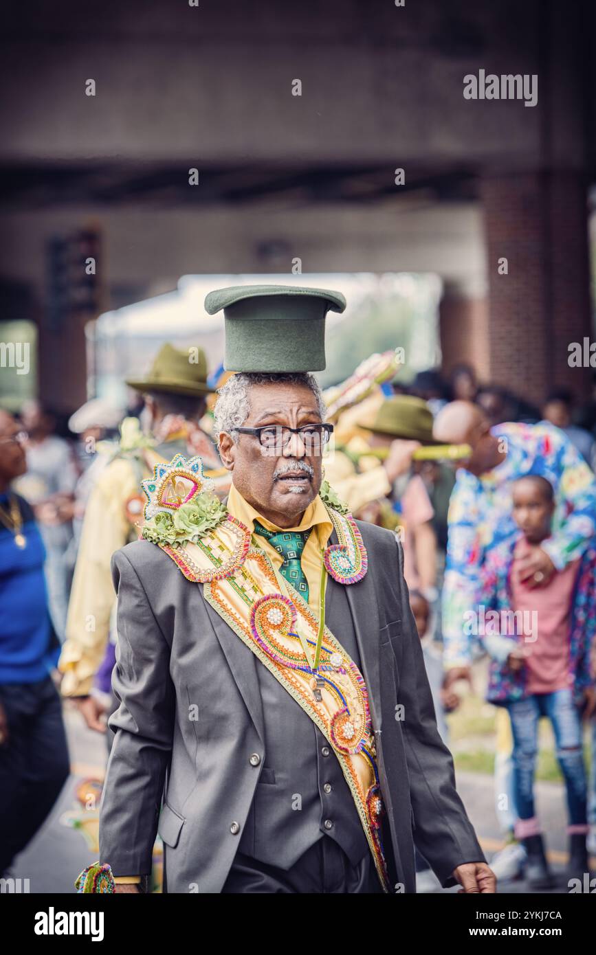 Un membre du Sudan social and Pleasure Club dans une parade de deuxième ligne se déplaçant dans les rues du quartier Treme à la Nouvelle-Orléans, en Louisiane. Banque D'Images
